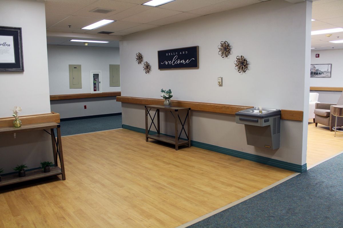 An empty dance studio with mirrors, barres, and decorative wall art.