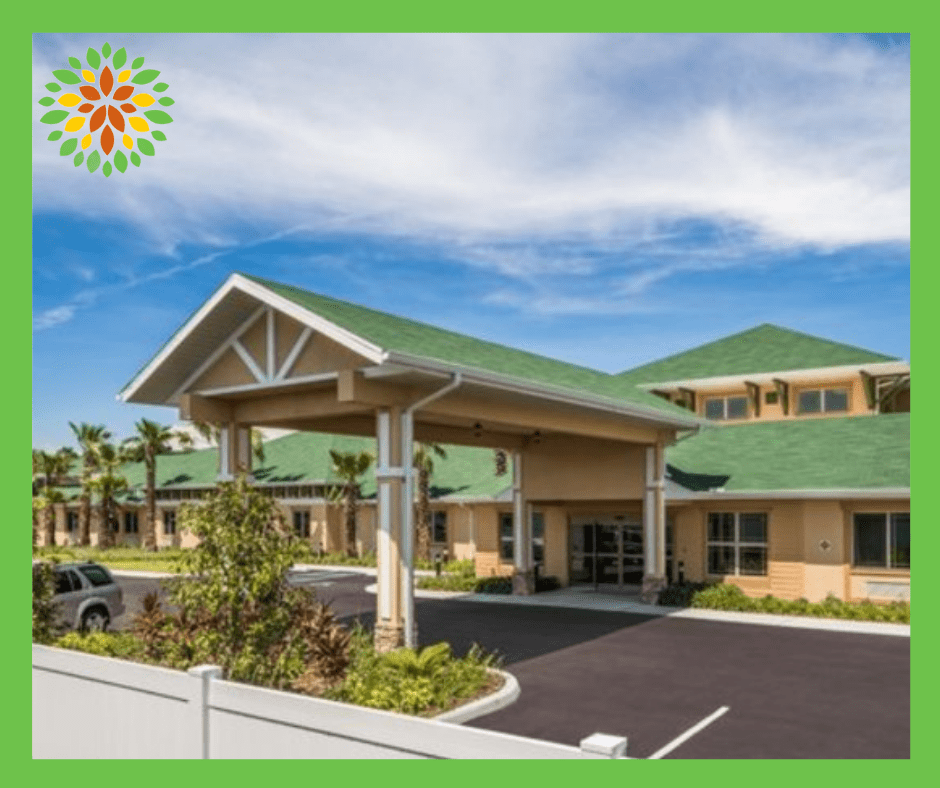 A modern building with a green roof and landscaped entrance.