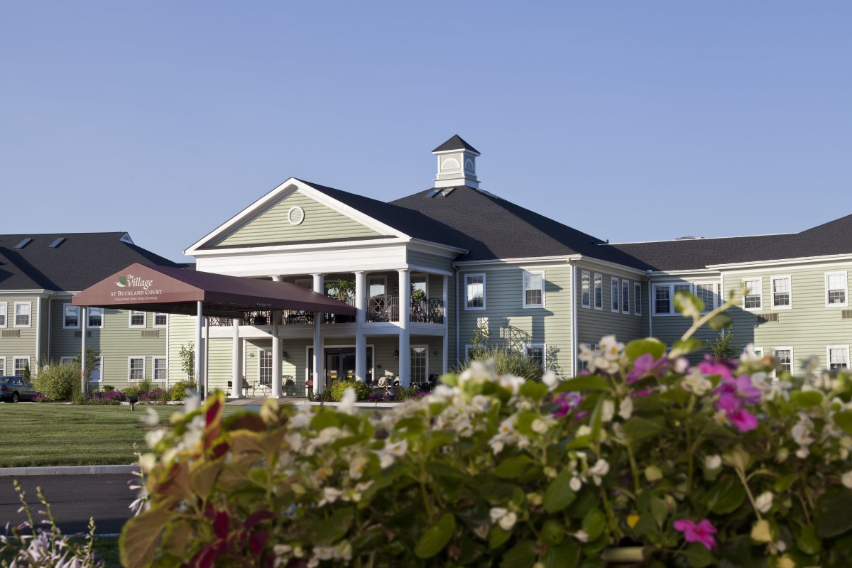 A picturesque building surrounded by vibrant flowers under a clear blue sky.