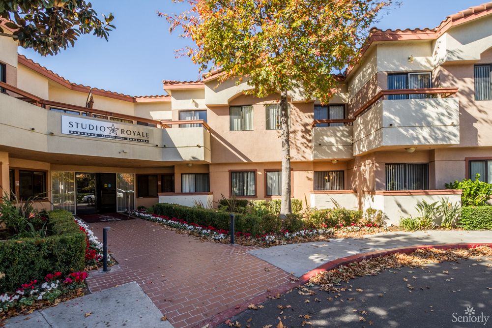 A sunny day outside a residential apartment building with a welcoming entrance.