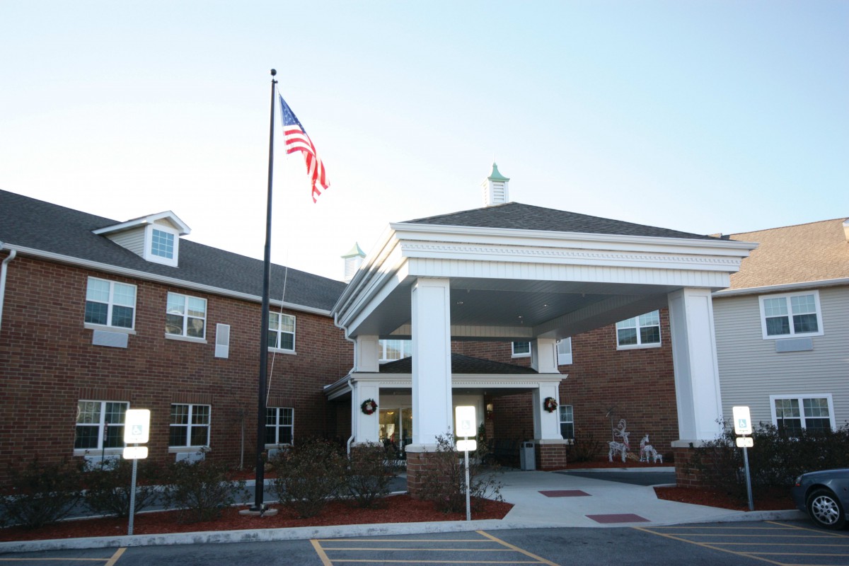 A brick building with an American flag and a grand entrance.