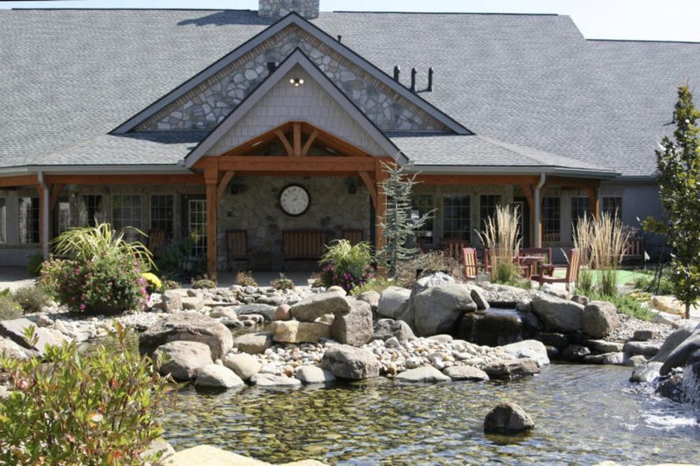 A beautiful house with a large pond and landscaped garden.