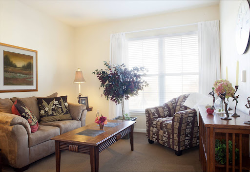 A cozy living room setup featuring a comfortable sofa, an armchair, and natural light streaming through the window.