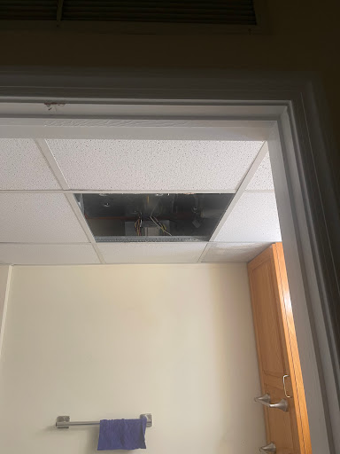 A damaged section of a ceiling tile, possibly indicating water damage or maintenance issues.