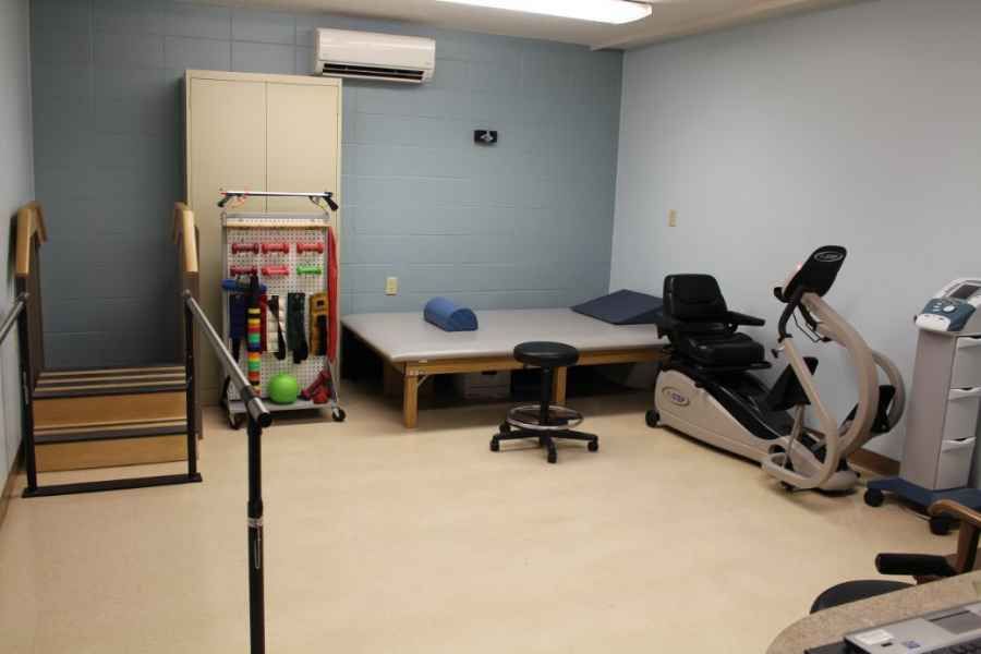 A physical therapy room equipped with various exercise and rehabilitation tools.