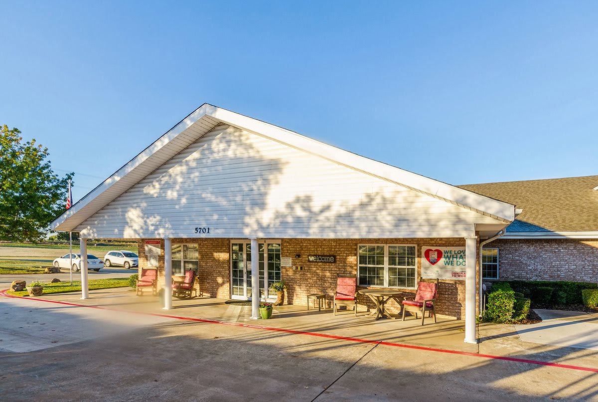 A sunlit building entrance with a welcoming patio area.