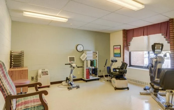 A small fitness room equipped with exercise machines for therapy and rehabilitation.