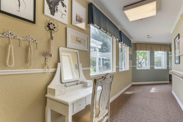 A bright hallway with a vanity table and artwork on the walls.