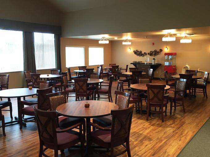 An empty dining room with neatly arranged tables and chairs.