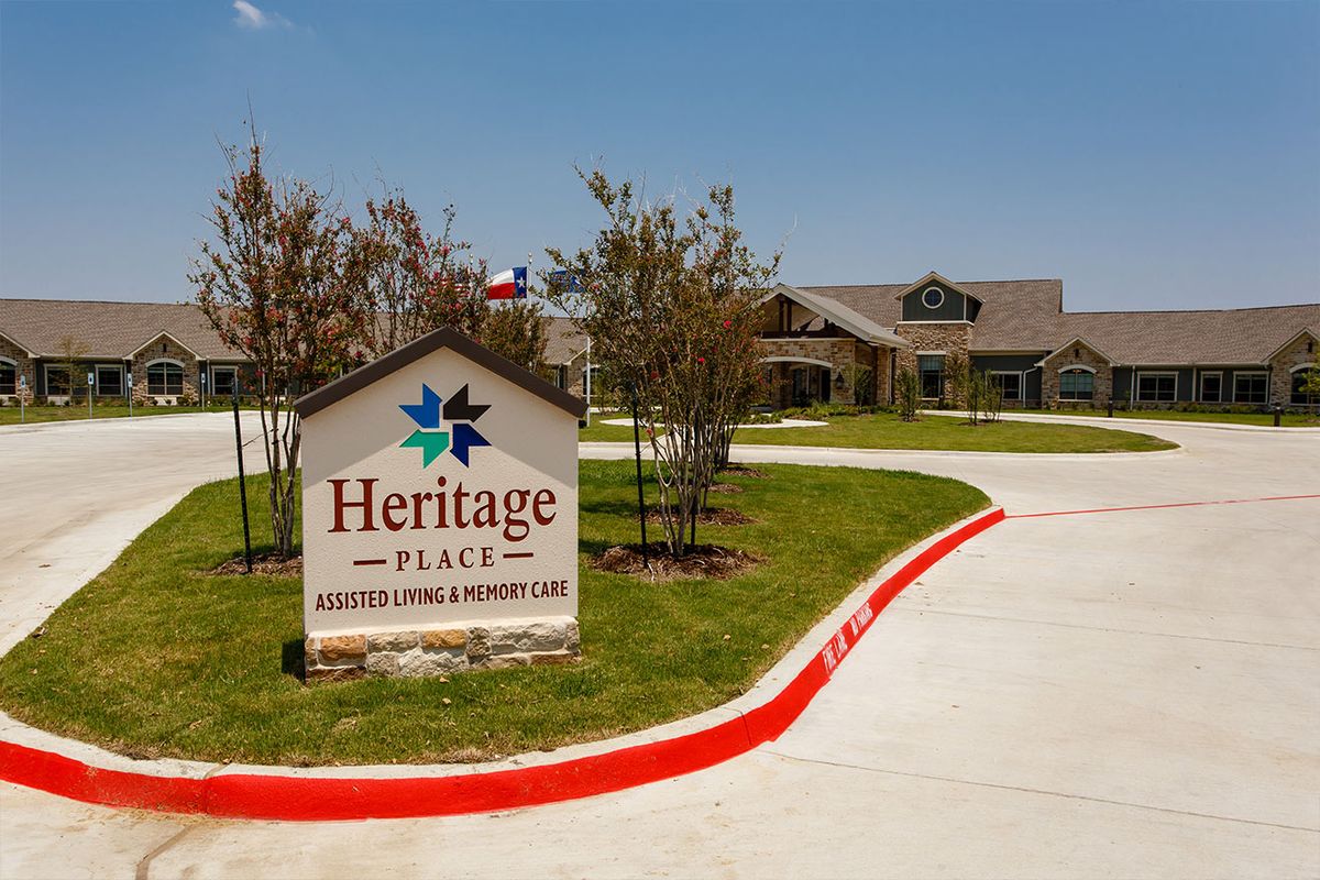 A view of Heritage Place, an assisted living and memory care facility with a clear, sunny sky.