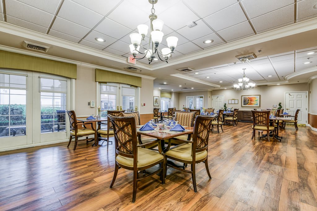 Elegant dining area with chandeliers and wooden floors.