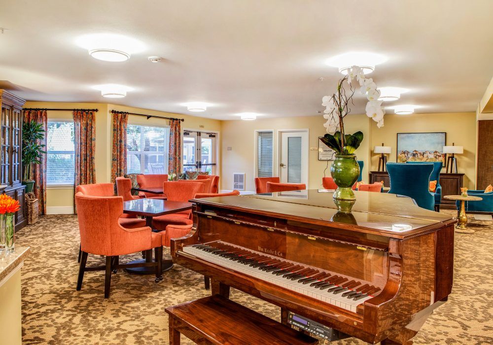 A cozy lounge area featuring a piano and vibrant seating with elegant decor.