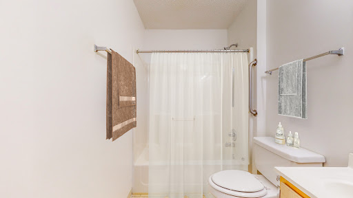 A clean and modern bathroom featuring a shower curtain, towel, and toilet.