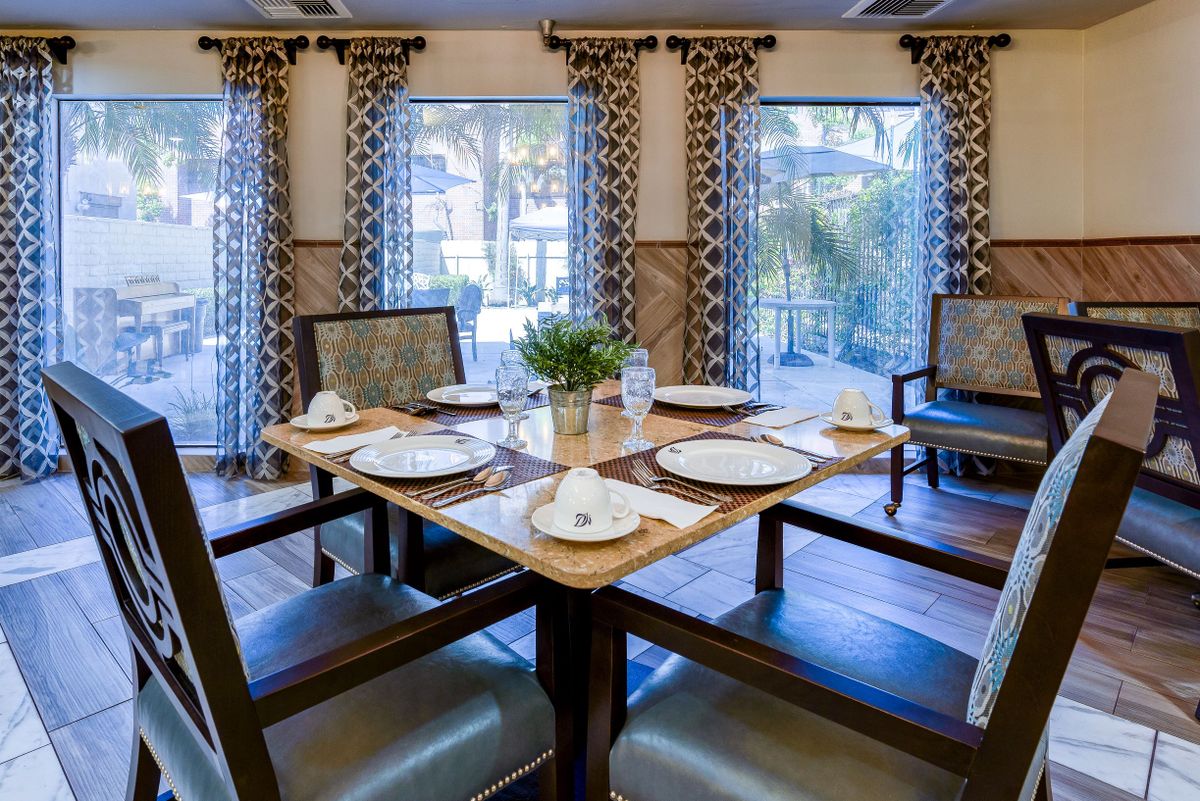 A well-decorated dining area with a neatly set table and elegant curtains.
