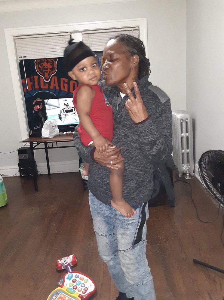 A person holding a child indoors, showing affection.