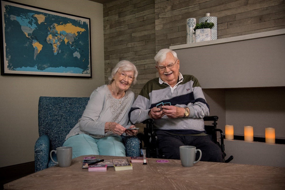 An elderly couple enjoying a cozy evening in the living room, playing games and sharing smiles.
