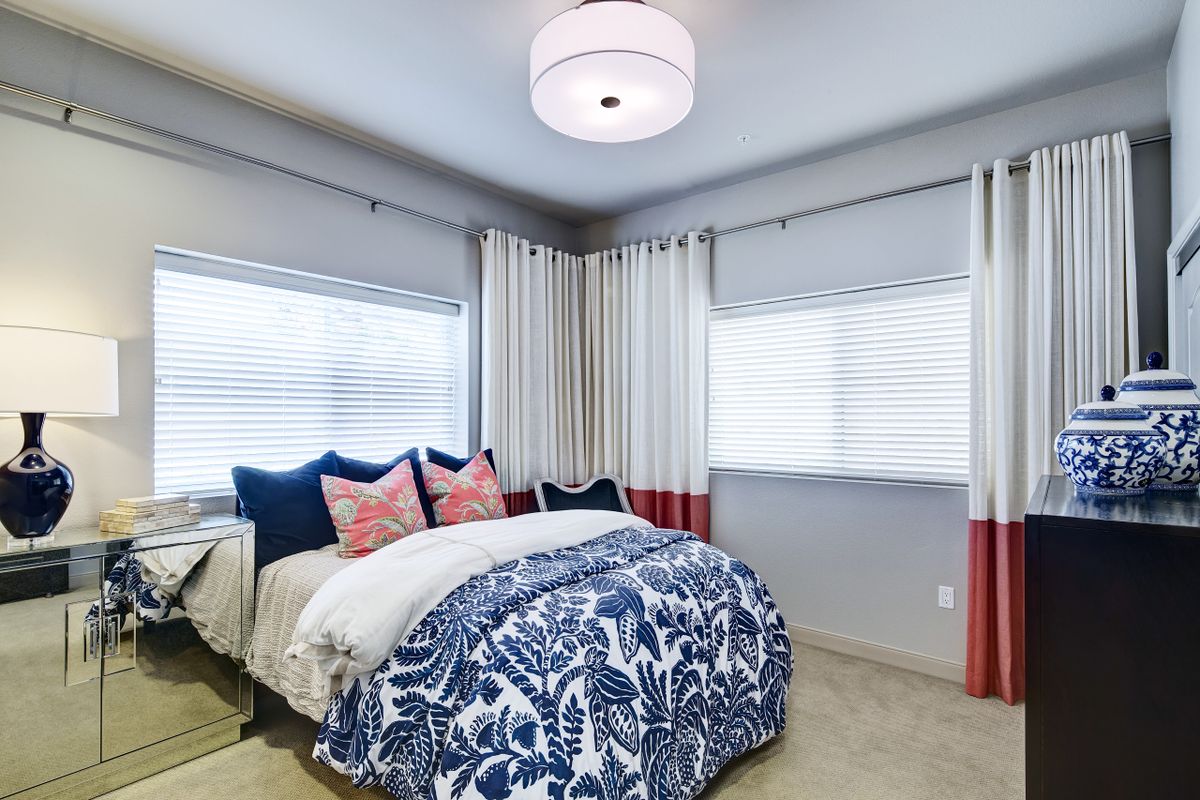 A cozy and modern bedroom with stylish bedding and curtains.