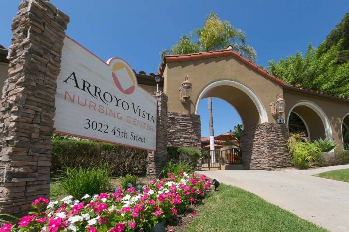 Entrance to Arroyo Vista with a landscaped sign and stone archway.