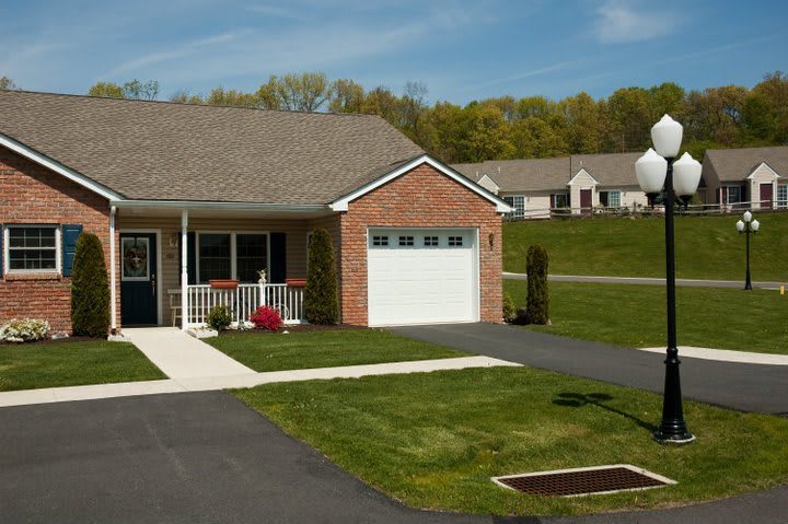 A suburban single-story house with a garage and a well-maintained lawn.