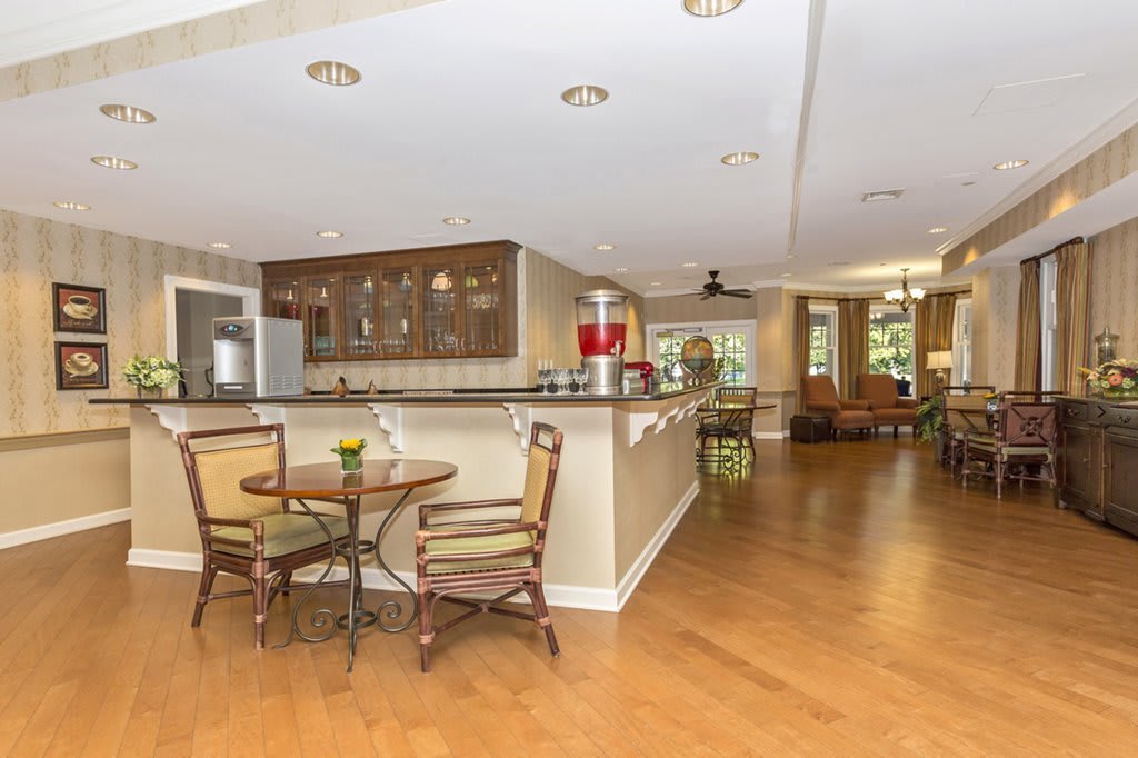 A modern open-concept kitchen and dining area with wood flooring and cozy seating.