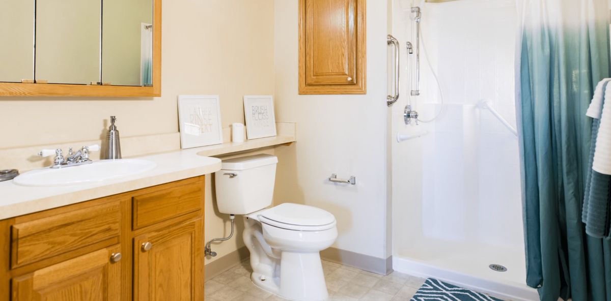 A clean and bright bathroom with wooden cabinets.