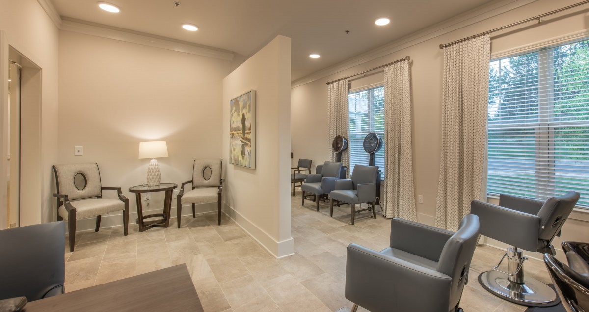 A modern waiting room with stylish seating and artwork, featuring soft lighting.
