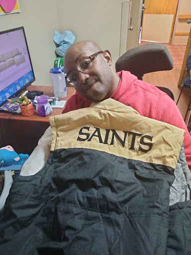 A person enjoying a casual moment with a SAINTS jacket.