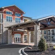 A modern residential building with a stone facade and welcoming entrance.