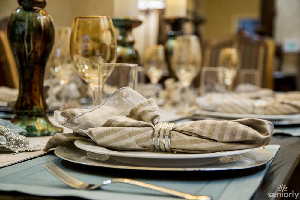 An elegantly set dining table with neatly folded napkins and polished dinnerware.