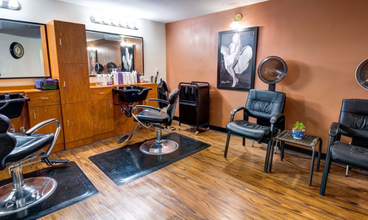 Empty hair salon with styling stations and chairs.
