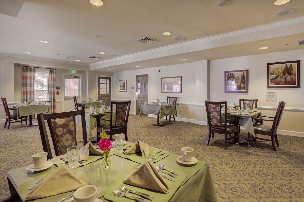 An elegantly set dining room with neatly arranged tables and chairs.