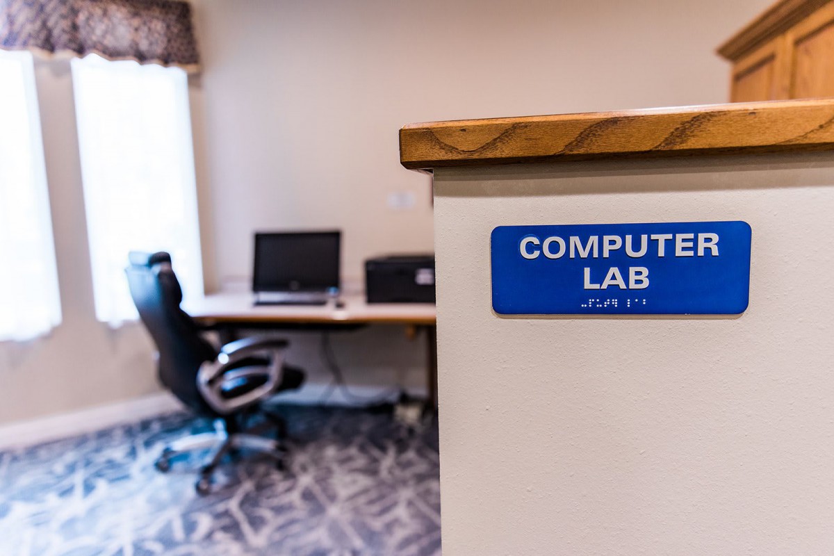 A computer lab featuring desks with computers and chairs, suggesting a workspace environment.
