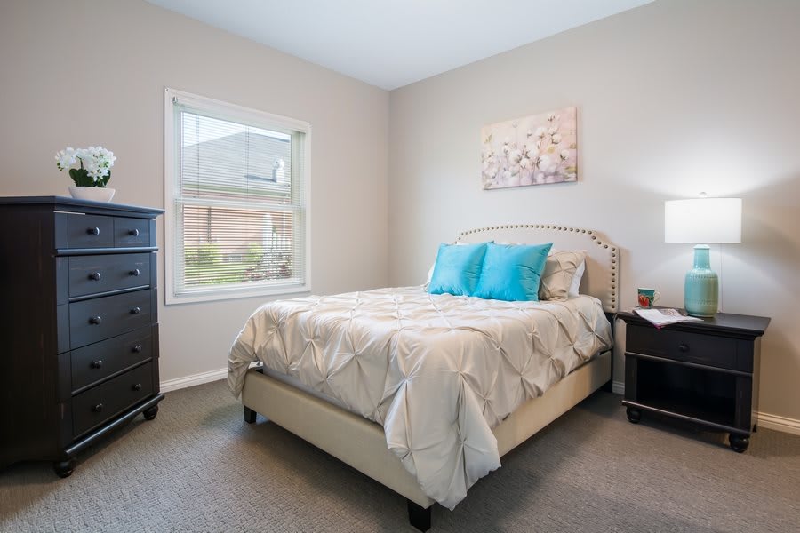 A cozy bedroom with a neatly arranged bed and soft lighting.