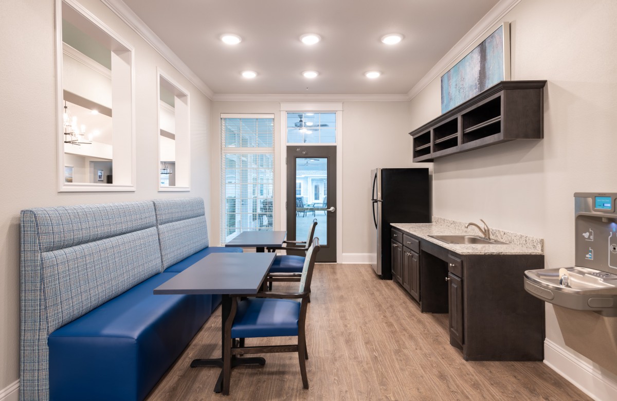 A modern kitchen and dining area with built-in seating and overhead lighting.