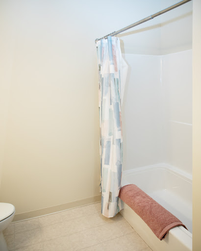A clean and simple bathroom featuring a shower curtain, towel, and toilet.