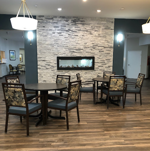 A modern lounge area featuring comfortable seating, a stylish fireplace, and warm lighting.