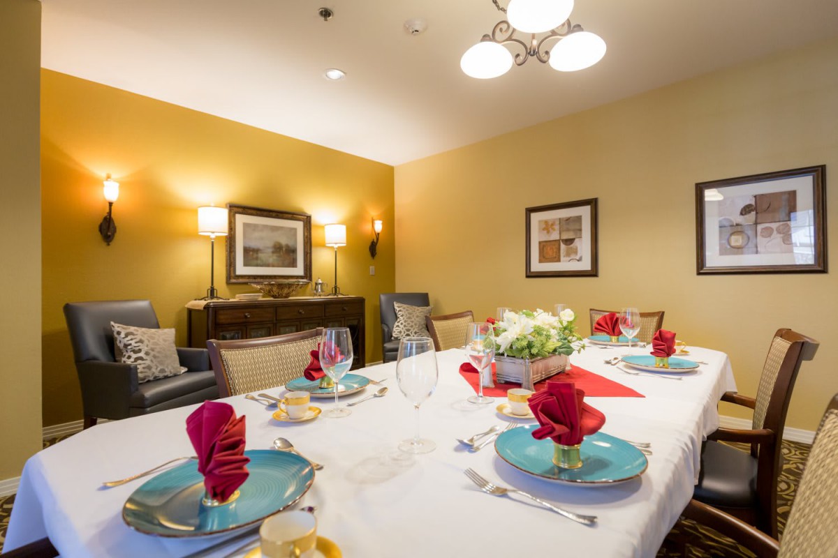 A beautifully set dining table in a well-lit room, complete with elegant decor and artwork on the walls.