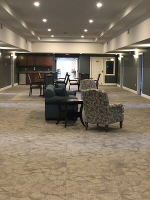 A spacious lounge area with comfortable seating arrangements and warm lighting.