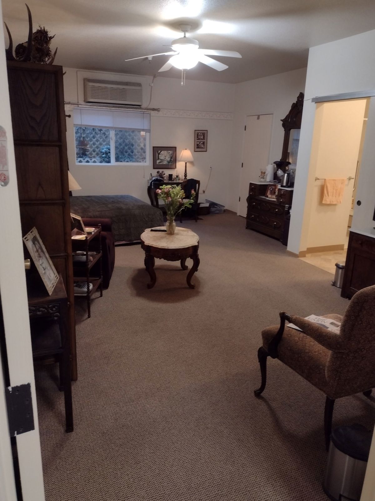 A cozy living room with various pieces of furniture and a window.