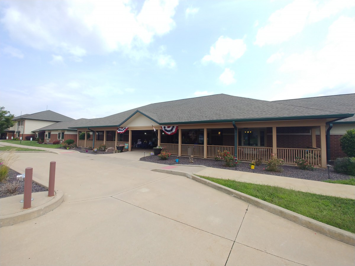 A commercial building with a parking lot under a cloudy sky.