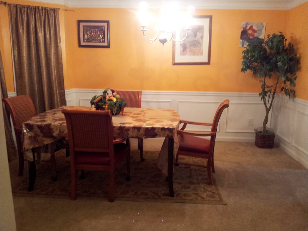 A cozy dining room with a table and chairs, featuring warm lighting and decorative elements.