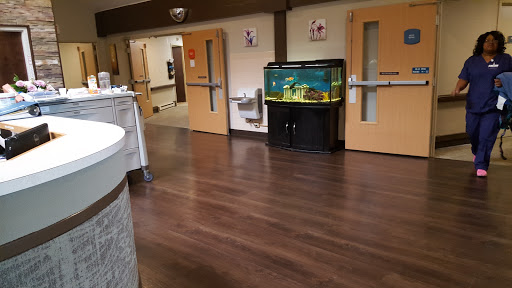 A view of a hospital interior featuring an aquarium and wooden flooring.