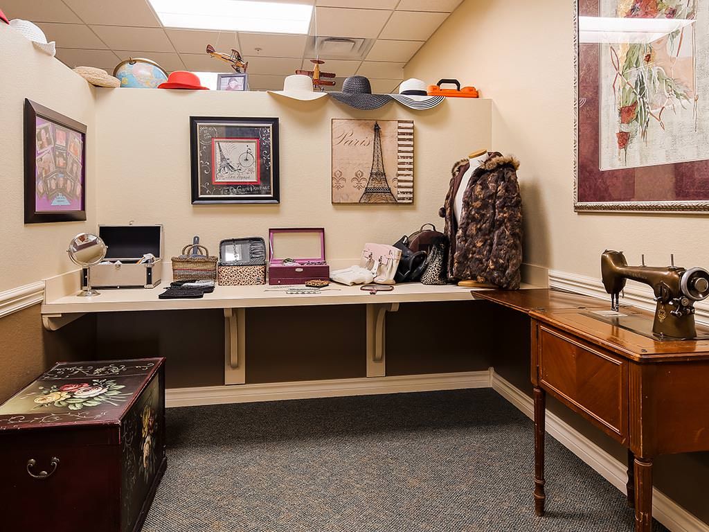 A small office space with hats displayed on the wall and various items on a desk.