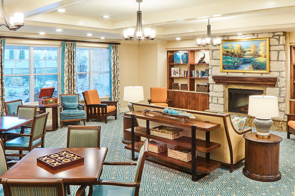 A cozy living room with a fireplace, comfortable seating, and a chessboard.