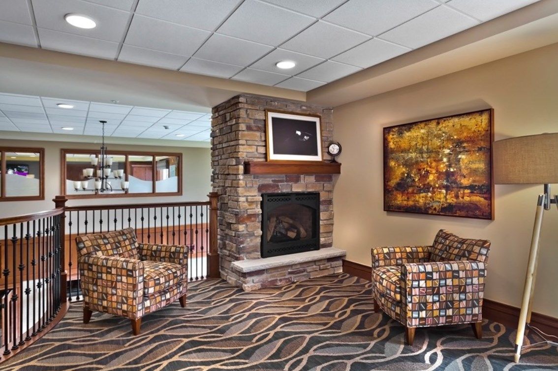 A cozy living room with a fireplace and two patterned armchairs.