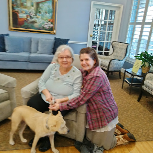 A warm moment shared between two individuals and their furry friend in a cozy indoor setting.