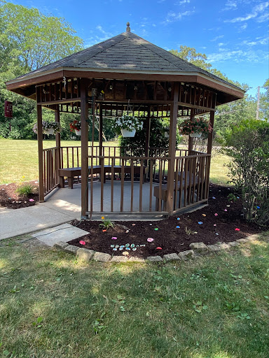A beautiful wooden gazebo surrounded by greenery, perfect for enjoying the outdoors.