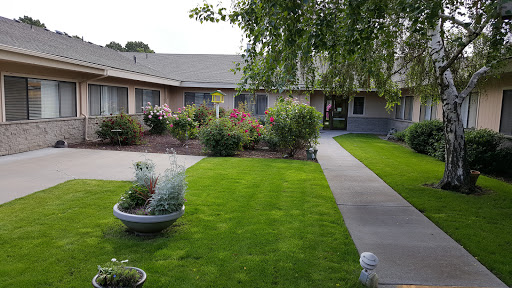 A serene residential courtyard featuring well-maintained lawns and vibrant flowers.