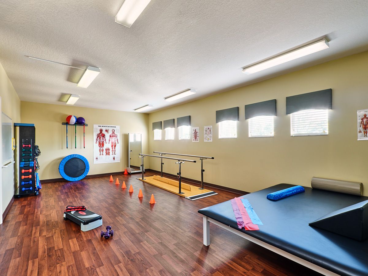 A well-equipped physical therapy room with various exercise tools and apparatus for rehabilitation.