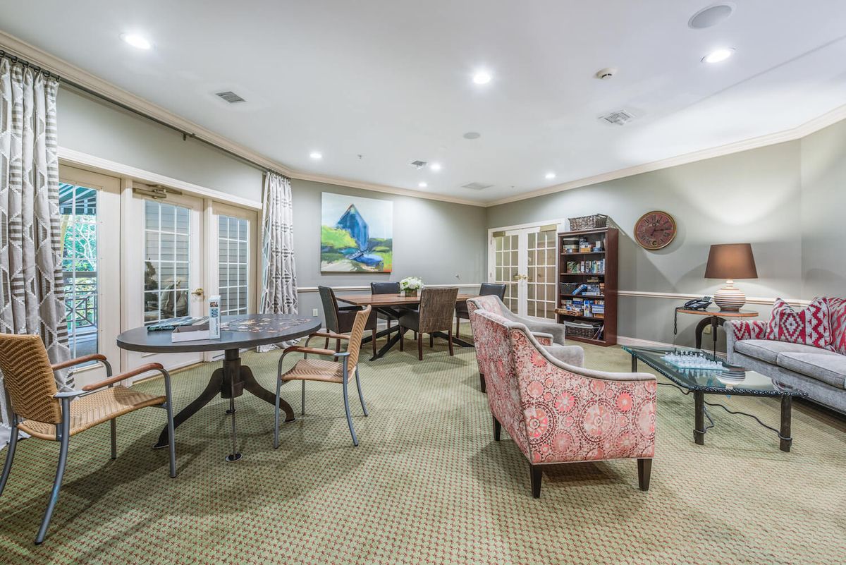 A cozy lounge area with comfortable seating, a bookshelf, and artwork on the walls.